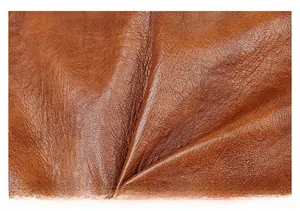 Close-up of brown soft leather texture with litchi grain on large tote bag