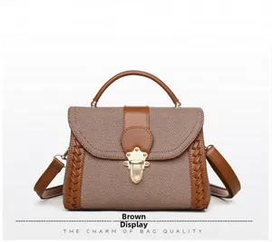 Detail of brown fabric shoulder bag featuring leather weave sides and gold metal buckle