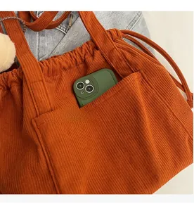 Detail of caramel corduroy tote bag featuring a practical outer pocket and large capacity