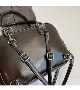 Detailed macro shot of vintage dark glossy leather handbag with silver metallic hardware