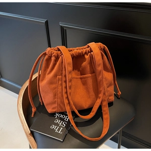 Detail of vintage orange corduroy tote bag with drawstring and textured outer pocket