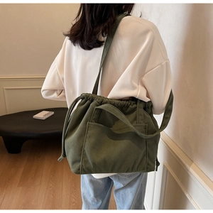 Detail of olive green corduroy bag with drawstring closure and large front pocket on back