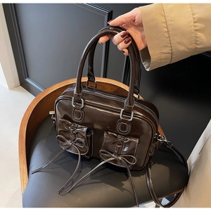 Detail of dark brown vintage bowling bag with bow-knot pockets and white contrast stitching