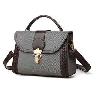 Grey textured fabric and brown leather handbag with gold buckle in 45-degree view