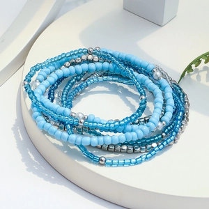 Macro shot of layered bohemian ocean style beaded bracelets with blue and silver beads