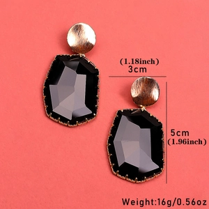 Fashionable geometric black crystal drop earrings with gold studs on pink background