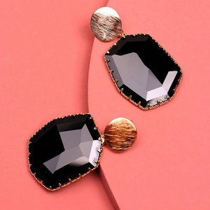 Chic gold-tone claw-set earrings with oversized black octagonal crystals on pink display