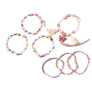 Set di 7 braccialetti di perline bohémien con ciondolo a farfalla e nappe su sfondo bianco