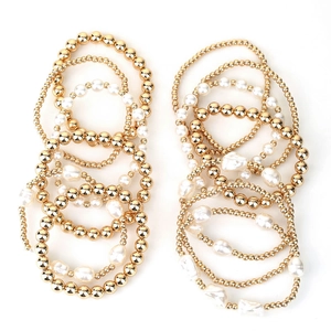 Detail of 13-piece layered bracelet set with gold beads and faux white pearls