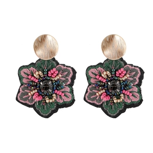 Vue détaillée des boucles d'oreilles fleur brodées à la main avec perles colorées