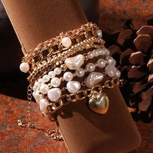 Détail d'un ensemble de bracelets multicouches avec cœur doré et perles sur velours rétro