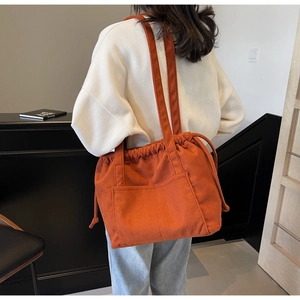 Orange corduroy tote bag detail showing drawstring closure and dual shoulder straps