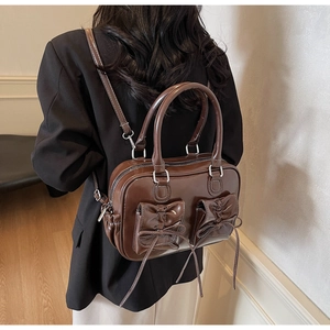 Detailed view of dark brown retro handbag with bow pockets and adjustable straps