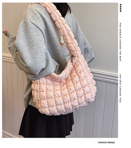 Macro shot of light pink quilted puff texture and soft fabric on a large shoulder bag