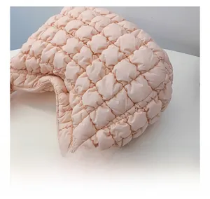 Detailed macro view of soft quilted fabric and zipper on pink cloud crossbody bag