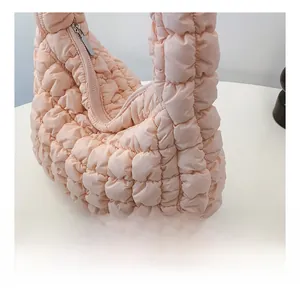 Detail showing the light pink quilted cloud bag fabric and high-quality zipper design