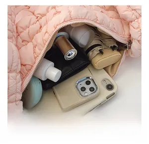 Spacious interior of pink quilted cloud bag holding phone, umbrella and cosmetics