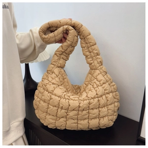 Detail of the soft quilted puff hobo bag with a lightweight beige cloud texture