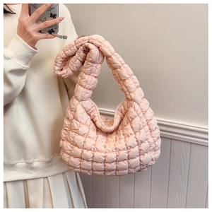 Detail of light pink quilted cloud bag featuring soft texture and puffy pleated design