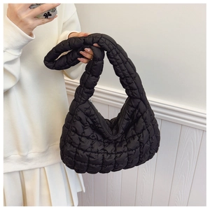 Detail of black quilted cloud bag with puffy texture and secure zipper closure