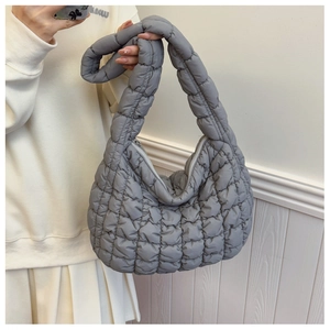 Detail of grey quilted bubble bag showing soft cloud-like texture and zip closure