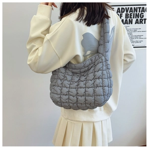 Close-up of a grey quilted puffer bag featuring soft texture and stylish stitching