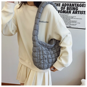 Detail of grey quilted cloud bag showing soft padded shoulder strap and puffy texture