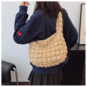 Close-up of beige quilted cloud bag texture and bubble-stitch polyester fabric design