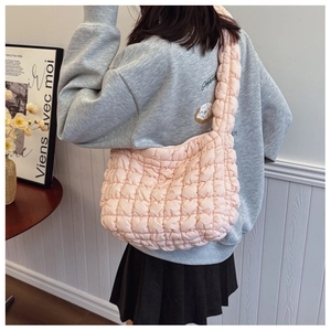 Close-up of light pink quilted cloud bag featuring bubble texture and soft strap