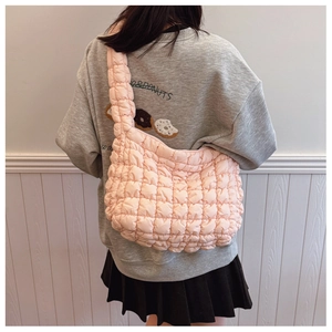 Detail of pink quilted puff shoulder bag showing spacious design and soft cloud texture