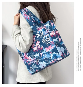 Dettaglio della borsa tote impermeabile con stampa floreale indossata su una spalla sola