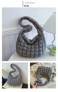 Close-up of grey quilted cloud bag with textured pleats and seamless shoulder strap