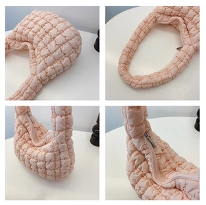 Detail view of pink quilted cloud bag showing zipper, strap, and soft diamond texture