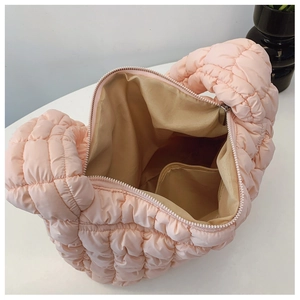 Detail view of pink quilted crossbody bag interior with zipper pocket and lining