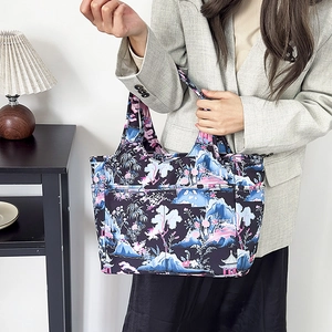 Dettaglio della borsa tote in Oxford con stampa floreale indossata da una modella