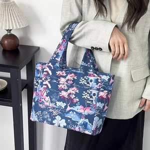 Dettaglio della borsa tote Oxford impermeabile con stampa floreale indossata da modella
