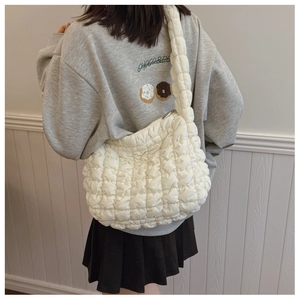Detail view of cream white quilted bubble shoulder bag with textured puffy fabric