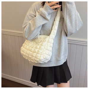 Detailed shot of white quilted puffer bag with crossbody strap and lightweight cloud design
