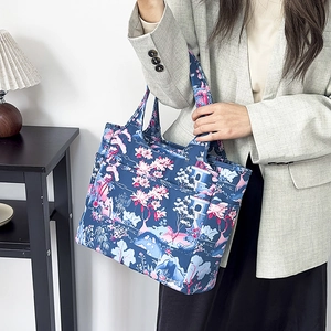 Dettaglio della borsa Oxford con stampa floreale e tasca laterale indossata da modella