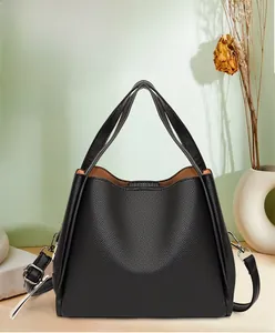 Detail of black pebbled leather bucket bag with top handles and side metal D-rings