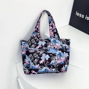 Dettaglio macro della borsa tote viola a fiori con tasche laterali su base bianca