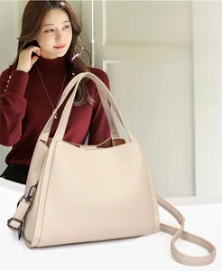 Chic beige lychee grain bucket bag with adjustable crossbody strap and dark hardware