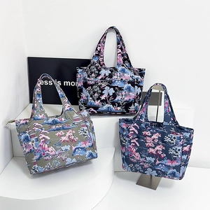 Dettaglio delle borse tote in Oxford stampate in verde oliva, nero e blu navy