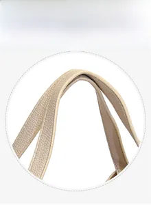 Detail of soft pebbled leather handle on a minimalist bucket bag with fine oil-edge finish