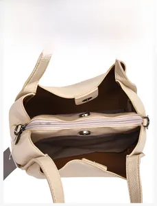 Interior view of beige leather bucket bag showing multi-layered compartments and zipper pocket