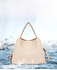 Close-up of beige lychee texture bucket bag showing waterproof leather surface and water splashes