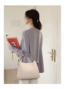 Detail of off-white grained leather bucket bag with elegant gathered silhouette and handle
