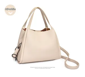Detail of off-white lychee grain leather bucket bag with gunmetal hardware and strap