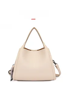 Detailed view of beige lychee pattern bucket bag with adjustable strap and grey hardware