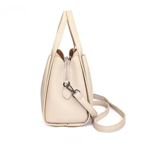 Side view of cream bucket bag showing layered organza structure and black matte hardware